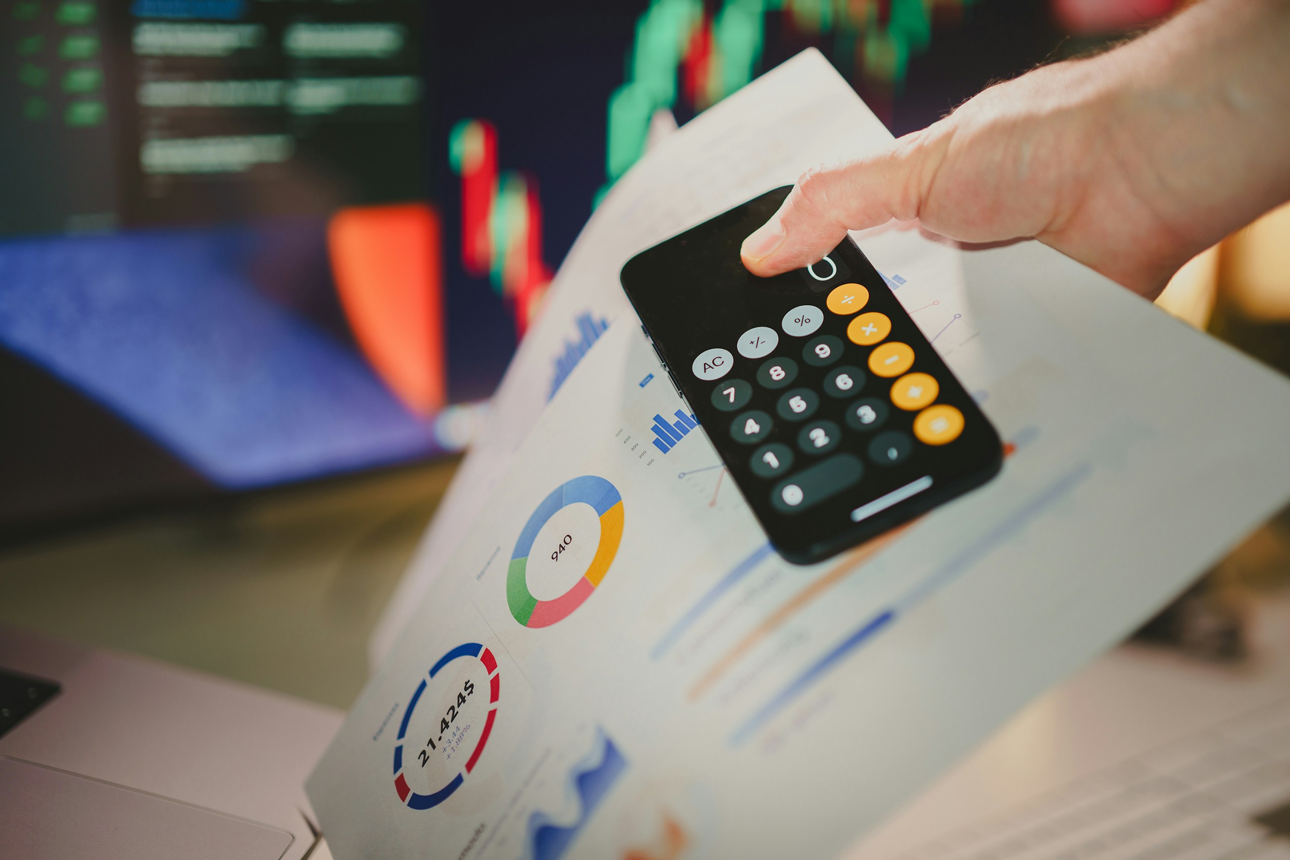 Person reviewing business figures with a calculator and charts