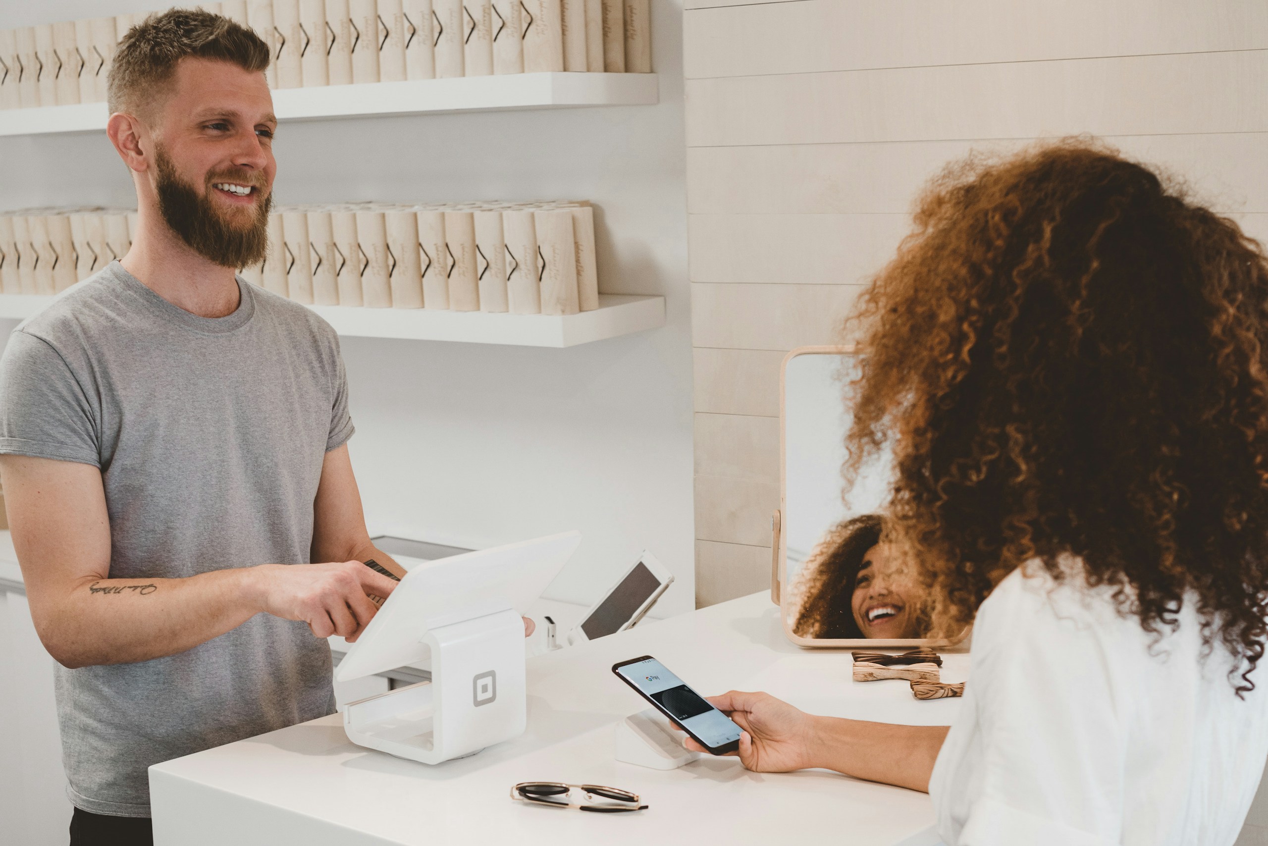 Small business owner smiling while serving a customer at the counter