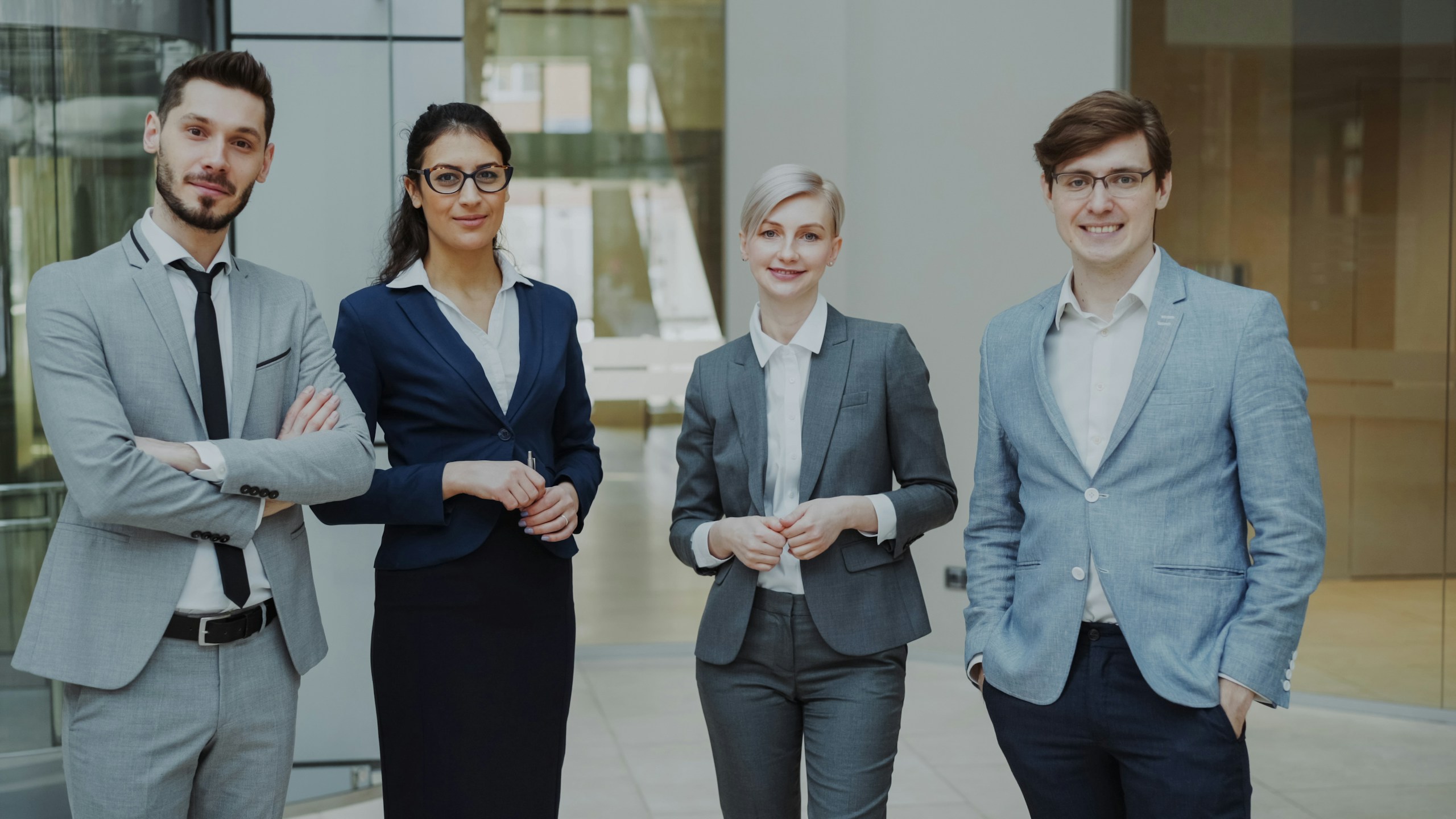Four professionals in business attire standing together