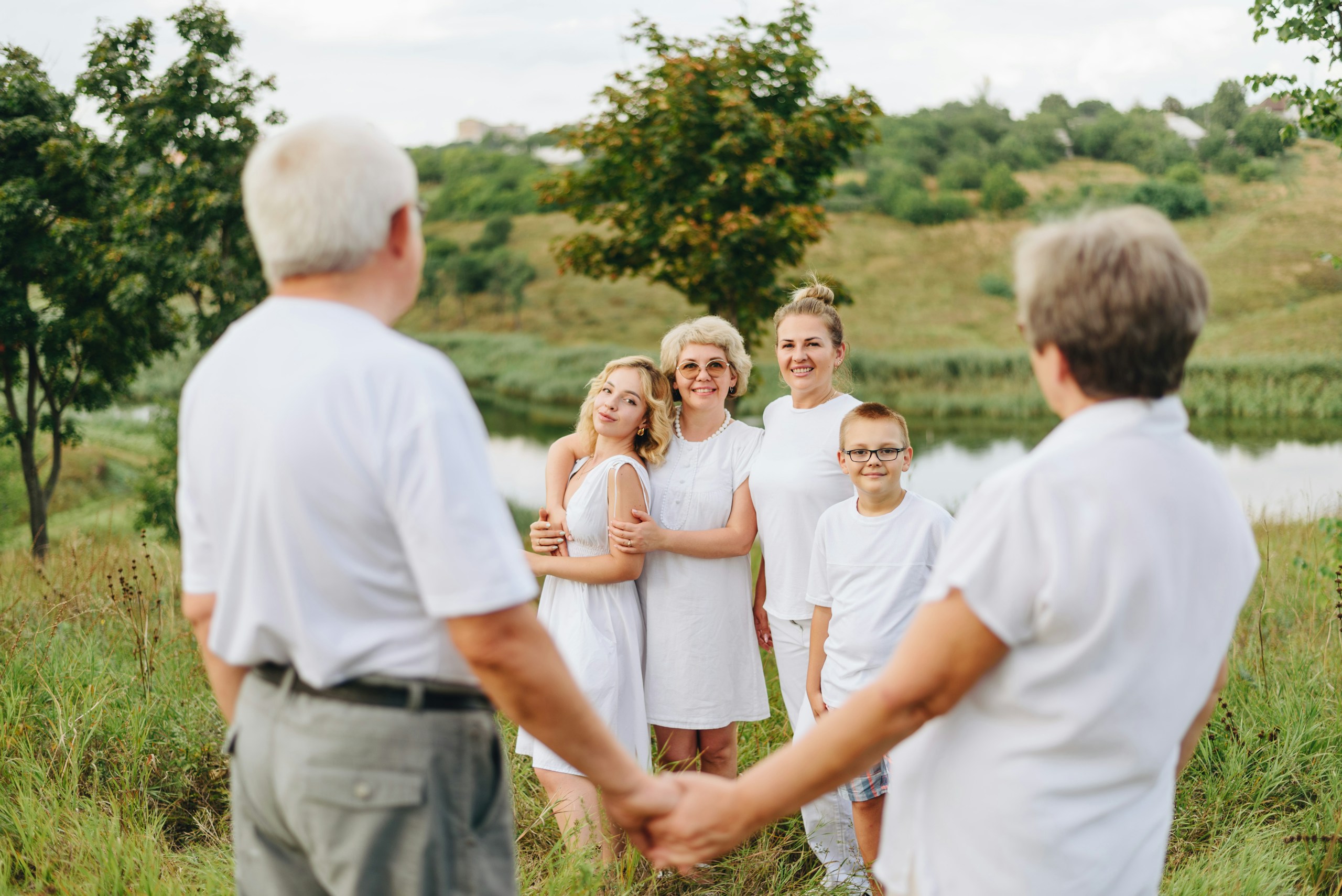 Grandparents and family members gathered together in a sunny field