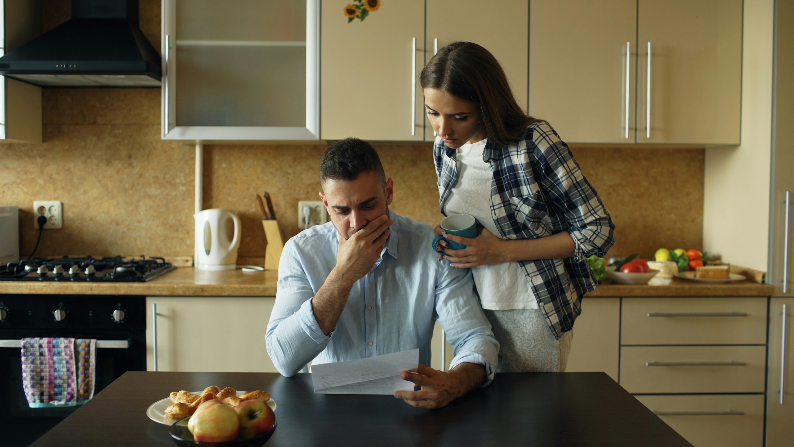 Couple reviewing household bills together at the kitchen counter