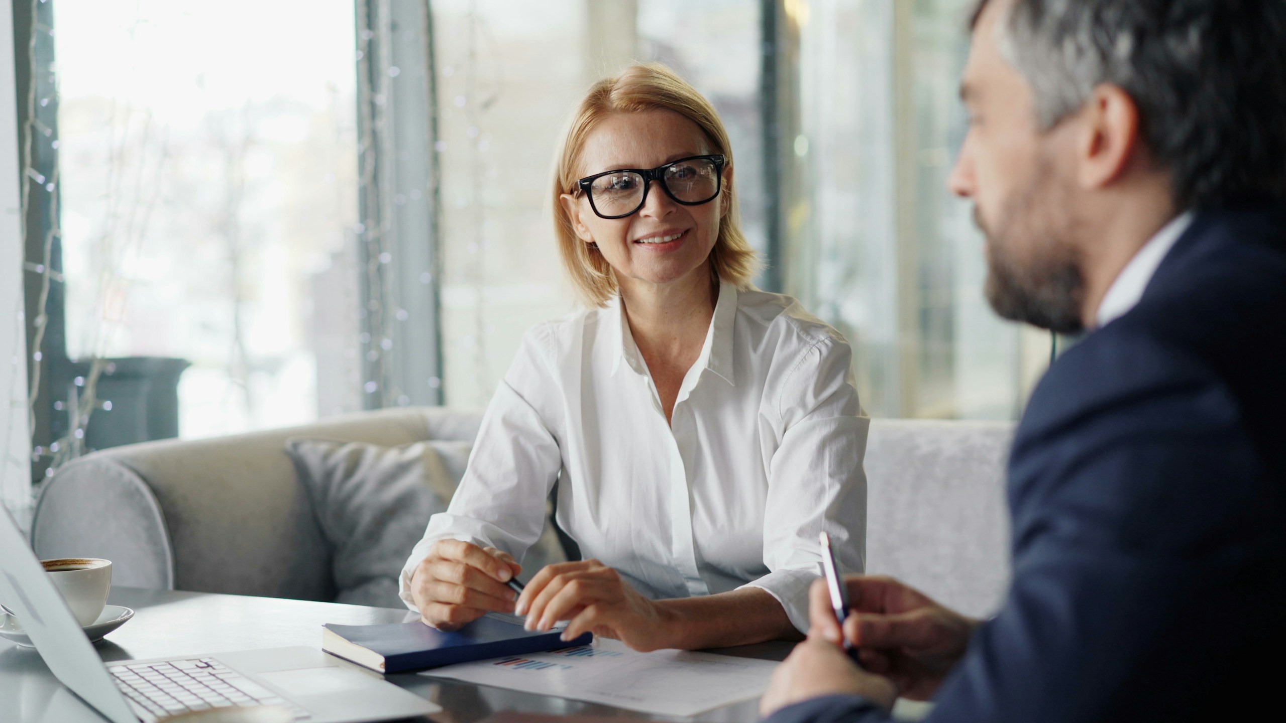 Financial professional talking with a client at a table