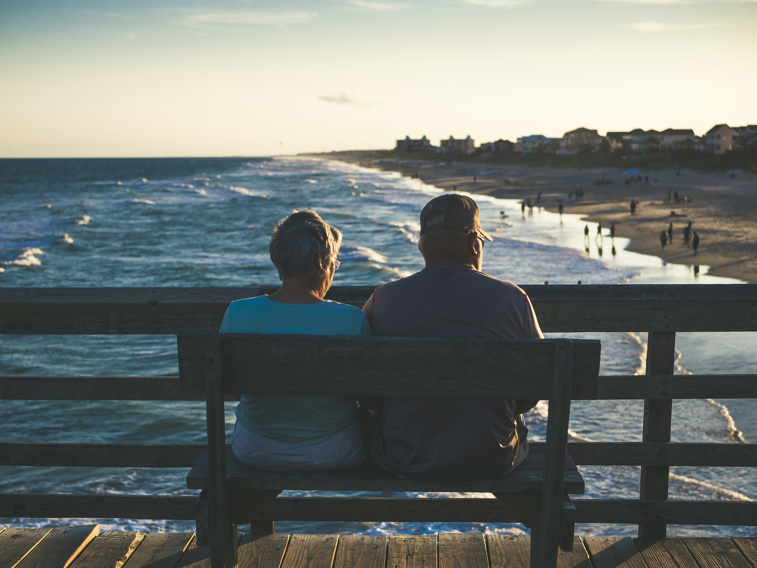 Couple relaxing on a bench overlooking the beach